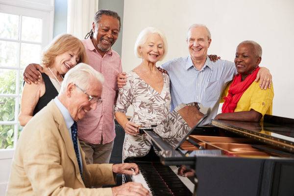 Image of a group of seniors singing around a piano