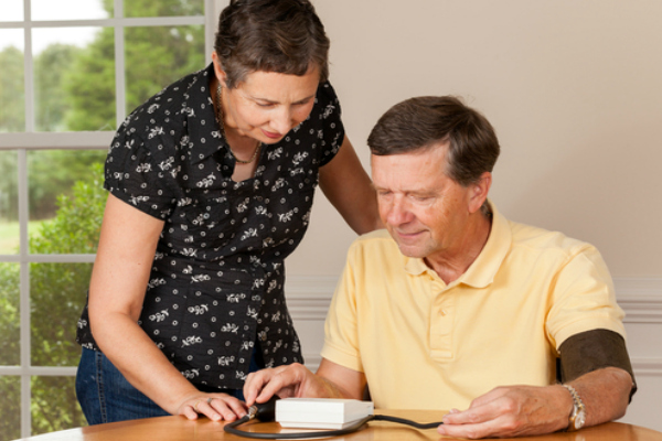 A man and his wife looking at his home heart monitor